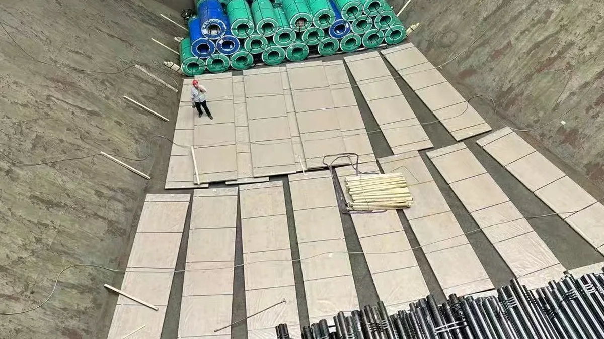 Mid-hold flat plates with a worker for scale during bulk-carrier stowage